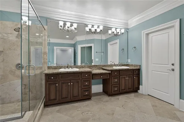a bathroom with a granite countertop sink a large mirror and a shower
