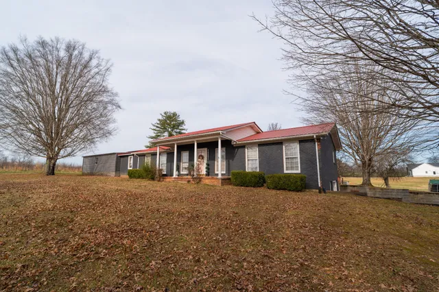 a front view of house with yard and trees around