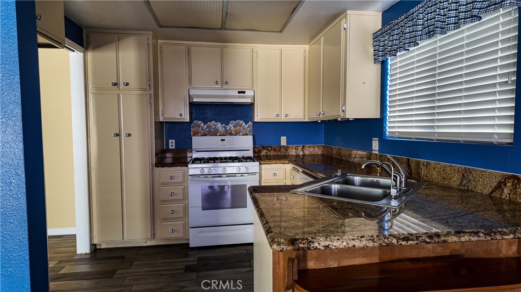 1419 Hancock Circle San Jacinto, CA 92583 - Photo 8 of 23 a kitchen with stainless steel appliances granite countertop a sink stove and refrigerator