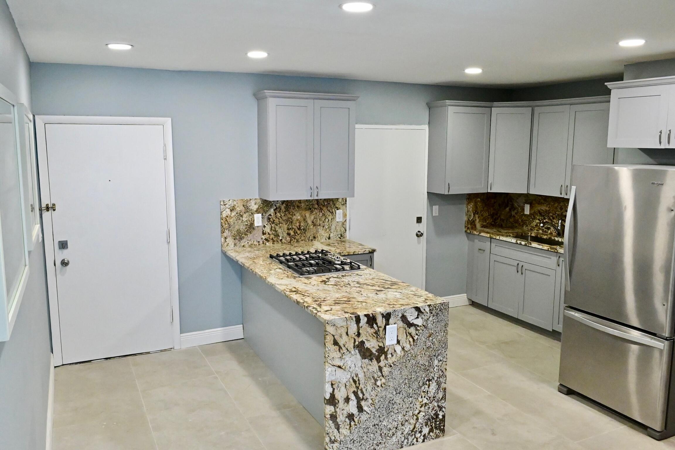 a kitchen with stainless steel appliances granite countertop a refrigerator a stove and a refrigerator
