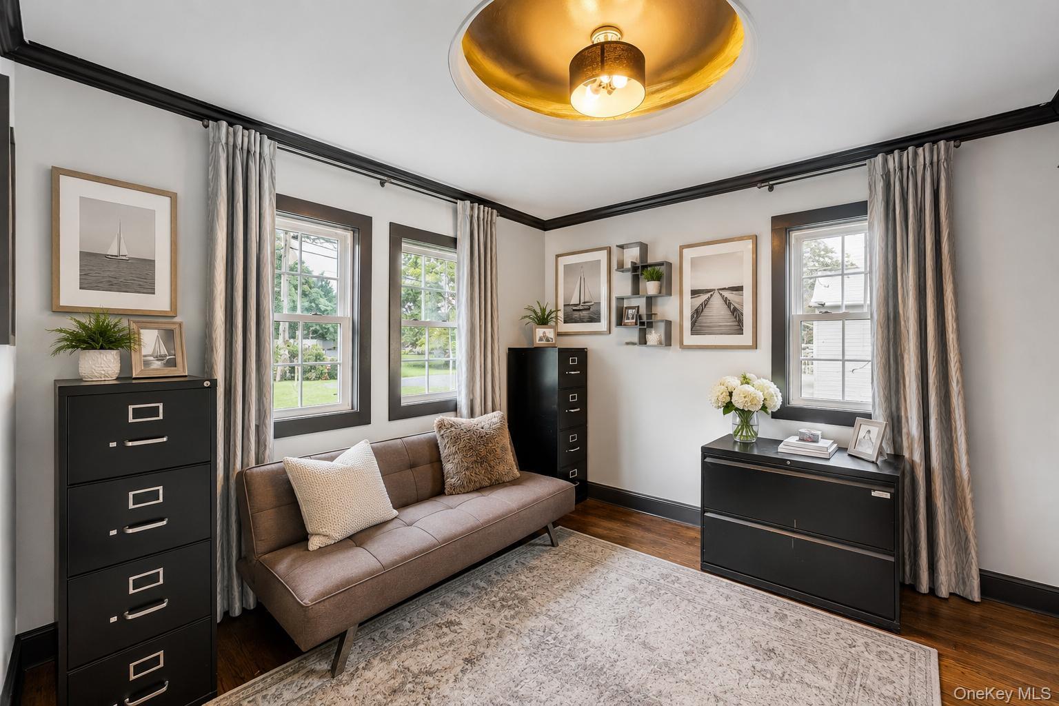19 Joan Road Bay Shore, NY 11706 - Photo 17 of 50 Interior space featuring dark wood-finish flooring, light grey walls with contrasting dark trim, and multiple windows providing natural illumination