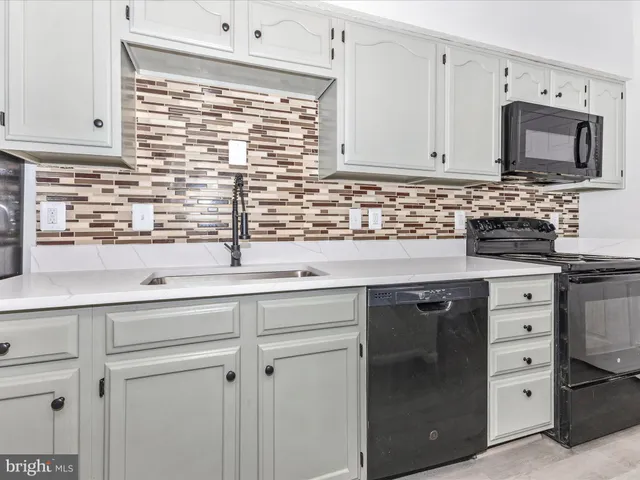 a kitchen with appliances a sink and cabinets