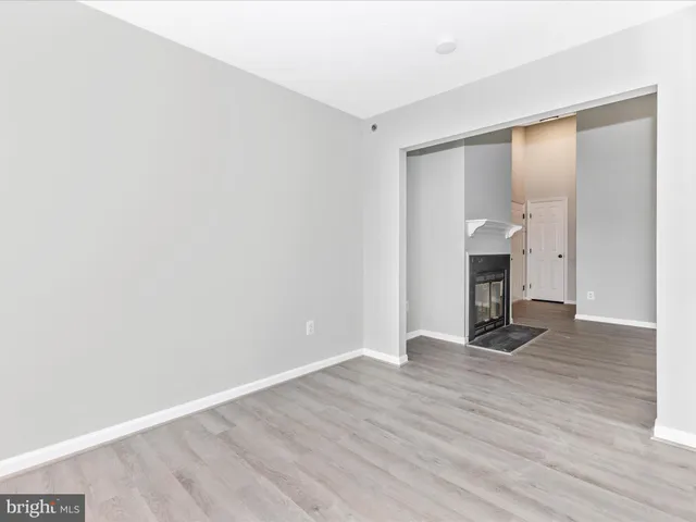an empty room with wooden floor and fireplace