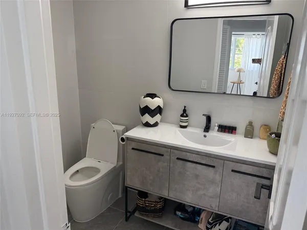 a bathroom with a toilet sink and mirror