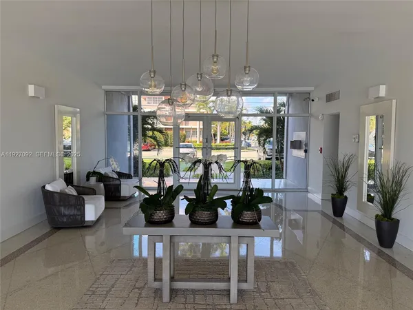 a room with lots of potted plants and large glass windows