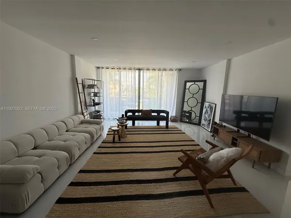a spacious bedroom with a bed a couch and large window