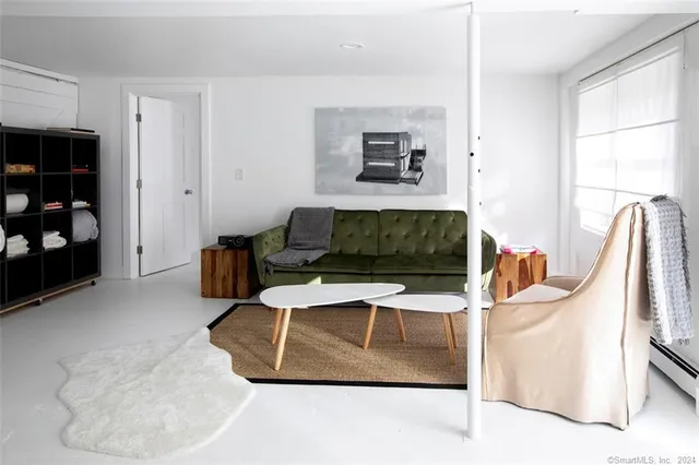 a living room with furniture a flat screen tv and a window