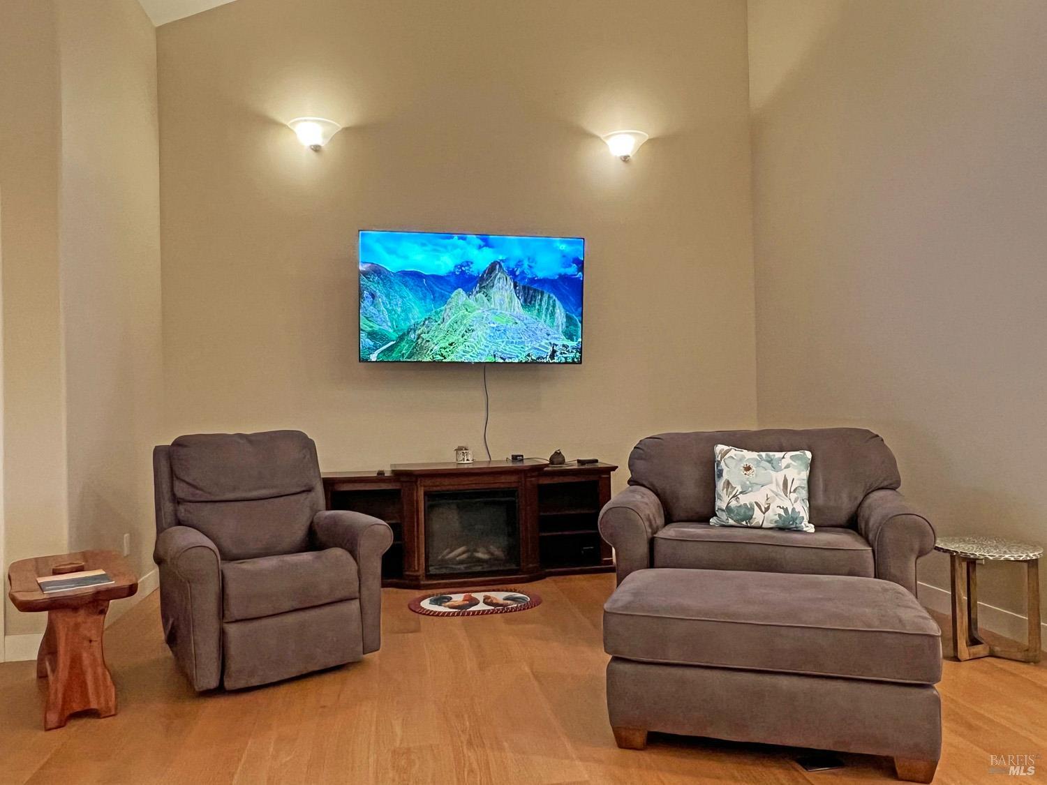 11401 Bakers Creek Road Redwood Valley, CA 95470 - Photo 21 of 70 a living room with furniture a couch and a flat screen with projector