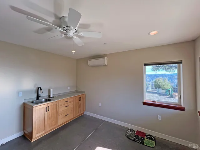 a view of a workspace with furniture and a window