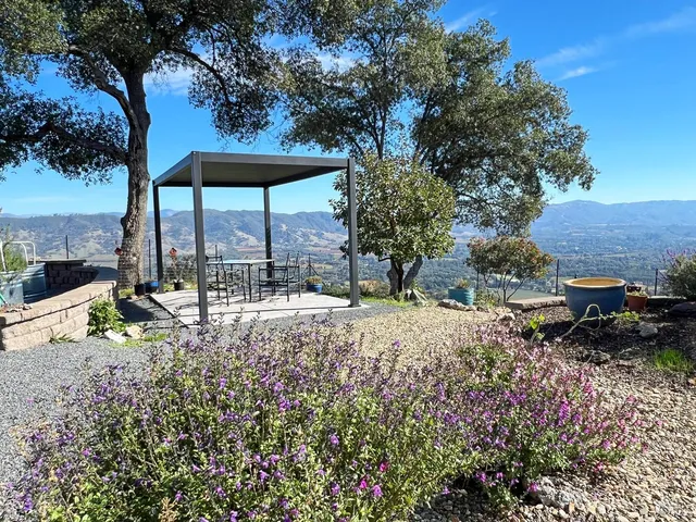 a view of a patio with table and chairs under an umbrella