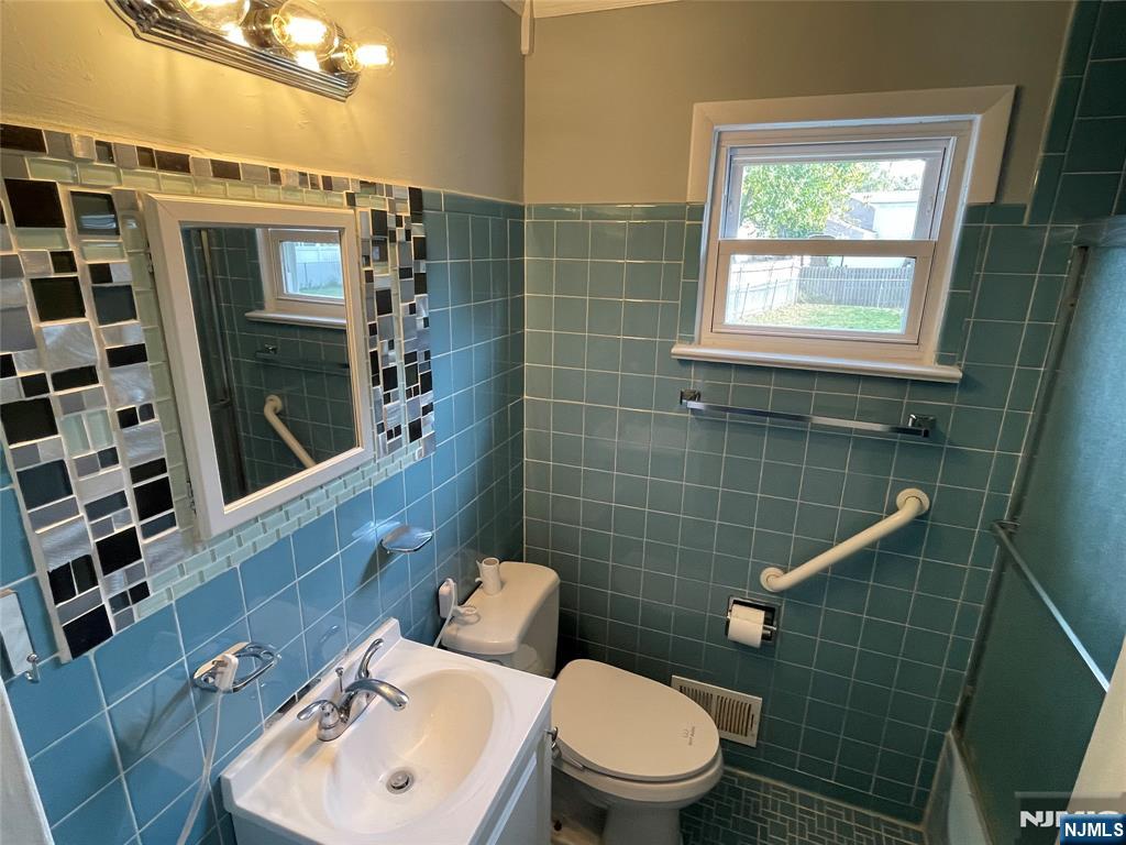 12 Fordham Road Oakland, NJ 07436 - Photo 8 of 26 a bathroom with a toilet a sink a shower and mirror