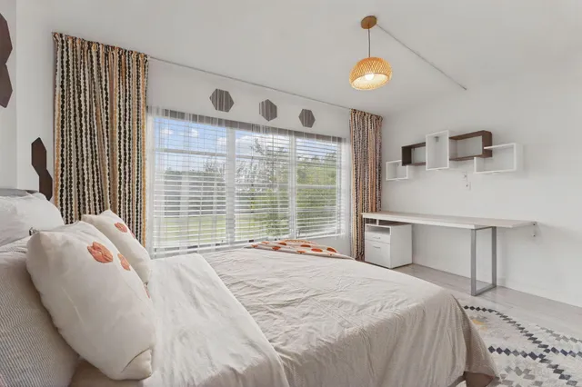 a bedroom with a large bed and a window