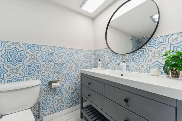 a bathroom with a sink mirror and toilet