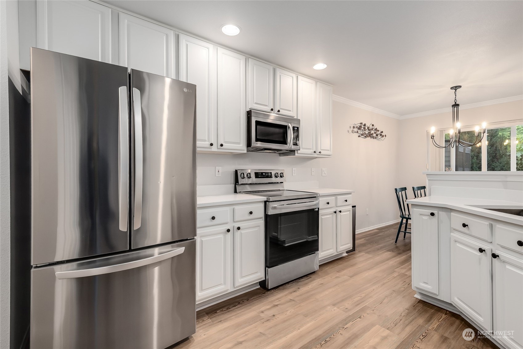 10030 Holly Drive, Unit 122 Everett, WA 98204 - Photo 11 of 29 a kitchen with stainless steel appliances white cabinets and wooden floor
