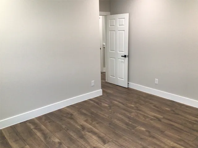 an empty room with wooden floor and closet
