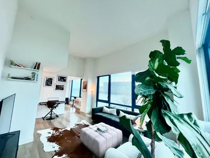 a living room with furniture flowers and a potted plant
