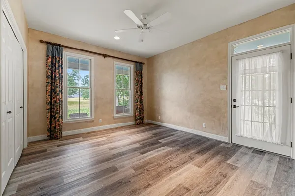 a view of an empty room with a window and wooden floor
