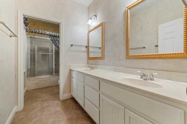 a spacious bathroom with 2 sink and a mirror