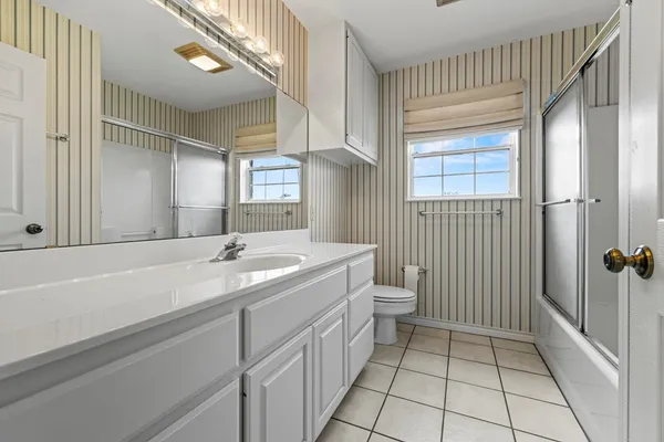 a bathroom with a double vanity sink toilet and shower