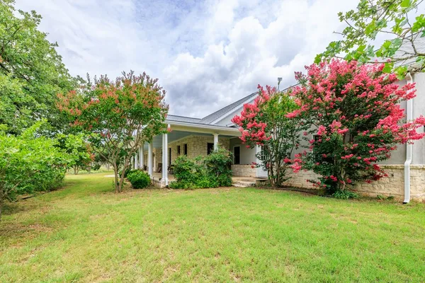 a front view of a house with a yard and plant