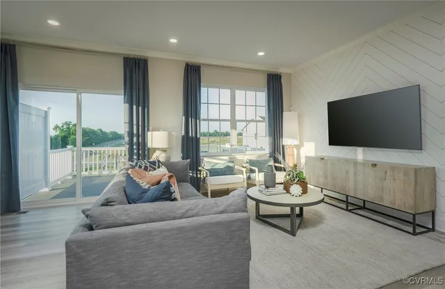 a living room with furniture a flat screen tv and a floor to ceiling window