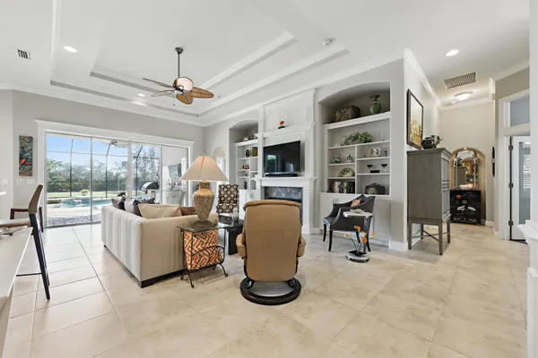 a living room with lots of white furniture and a large window