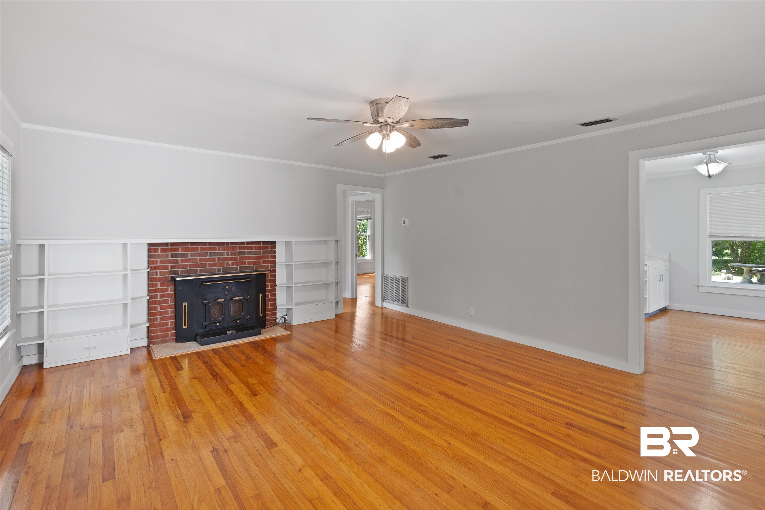 2126 Barron Place Mobile, AL 36605 - Photo 6 of 33 Unfurnished living room featuring a fireplace, ornamental molding, and light wood-type flooring