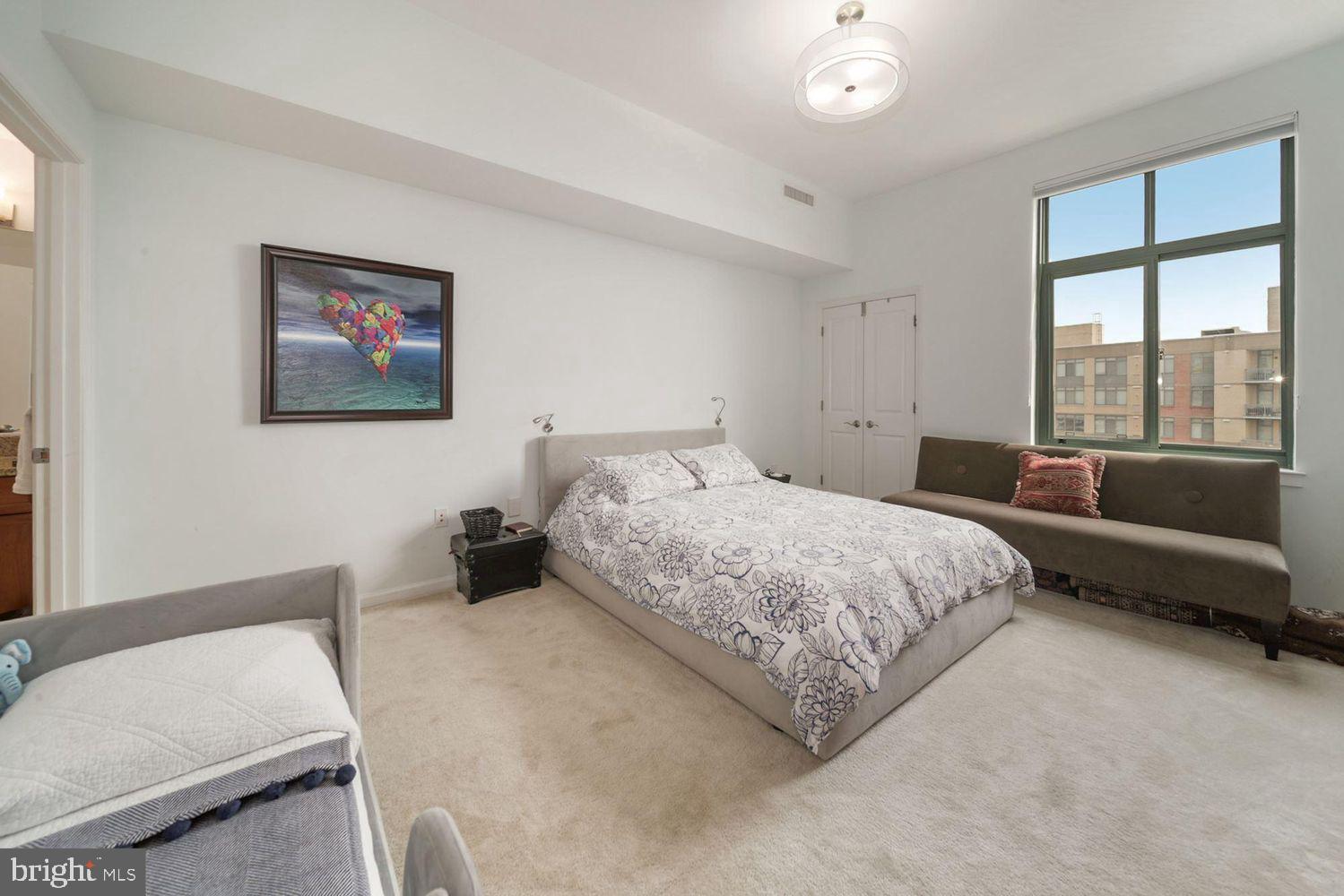 11700 Old Georgetown Road, Unit 1405 North Bethesda, MD 20852 - Photo 12 of 17 a spacious bedroom with a bed and glass window