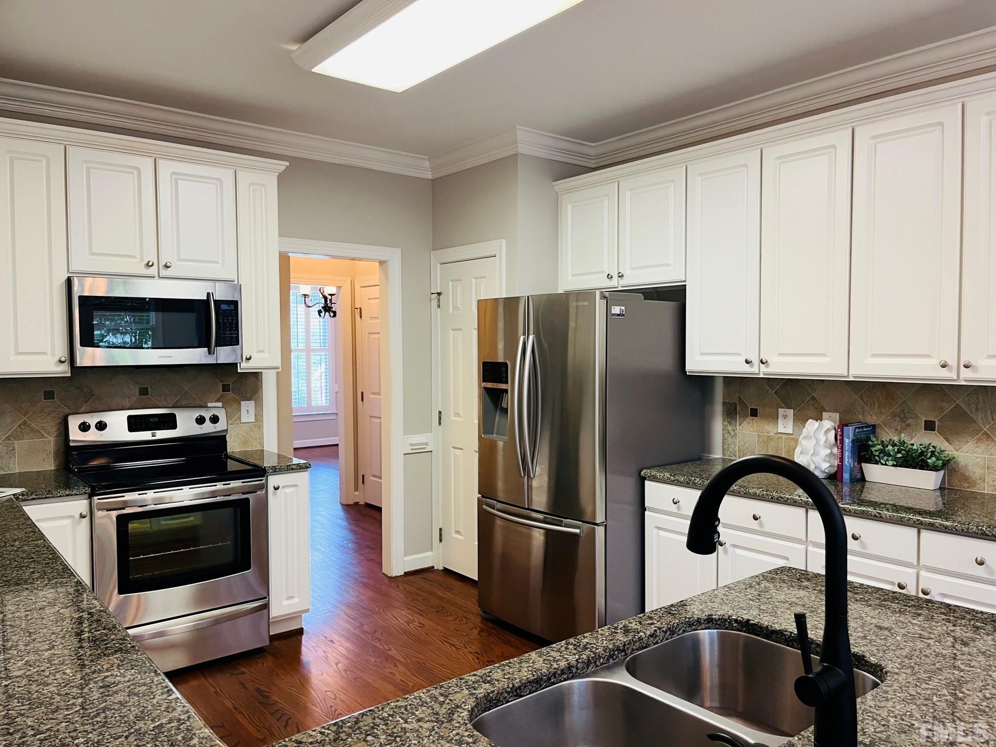 6317 Belle Crest Drive Raleigh, NC 27612 - Photo 2 of 29 a kitchen with a refrigerator stove and sink
