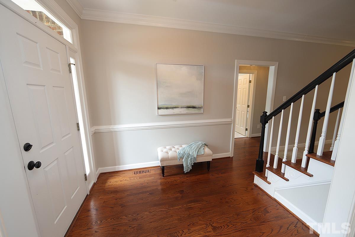 6317 Belle Crest Drive Raleigh, NC 27612 - Photo 6 of 29 a hallway with wooden floor stairs and furniture