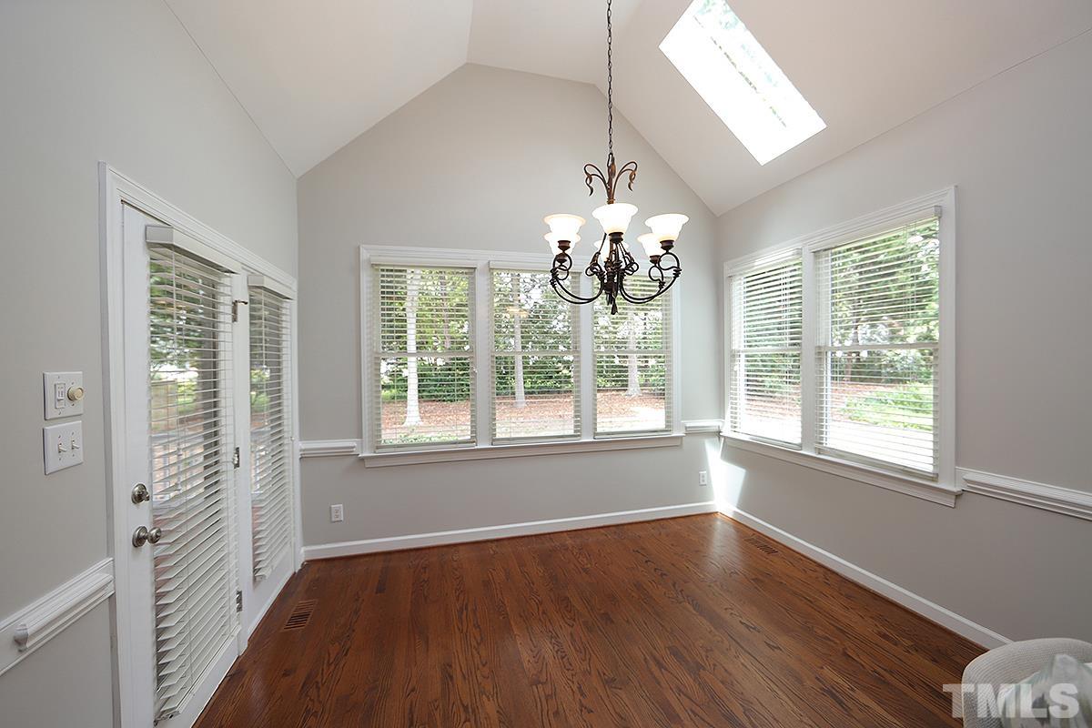 6317 Belle Crest Drive Raleigh, NC 27612 - Photo 7 of 29 a view of an empty room with wooden floor and a window