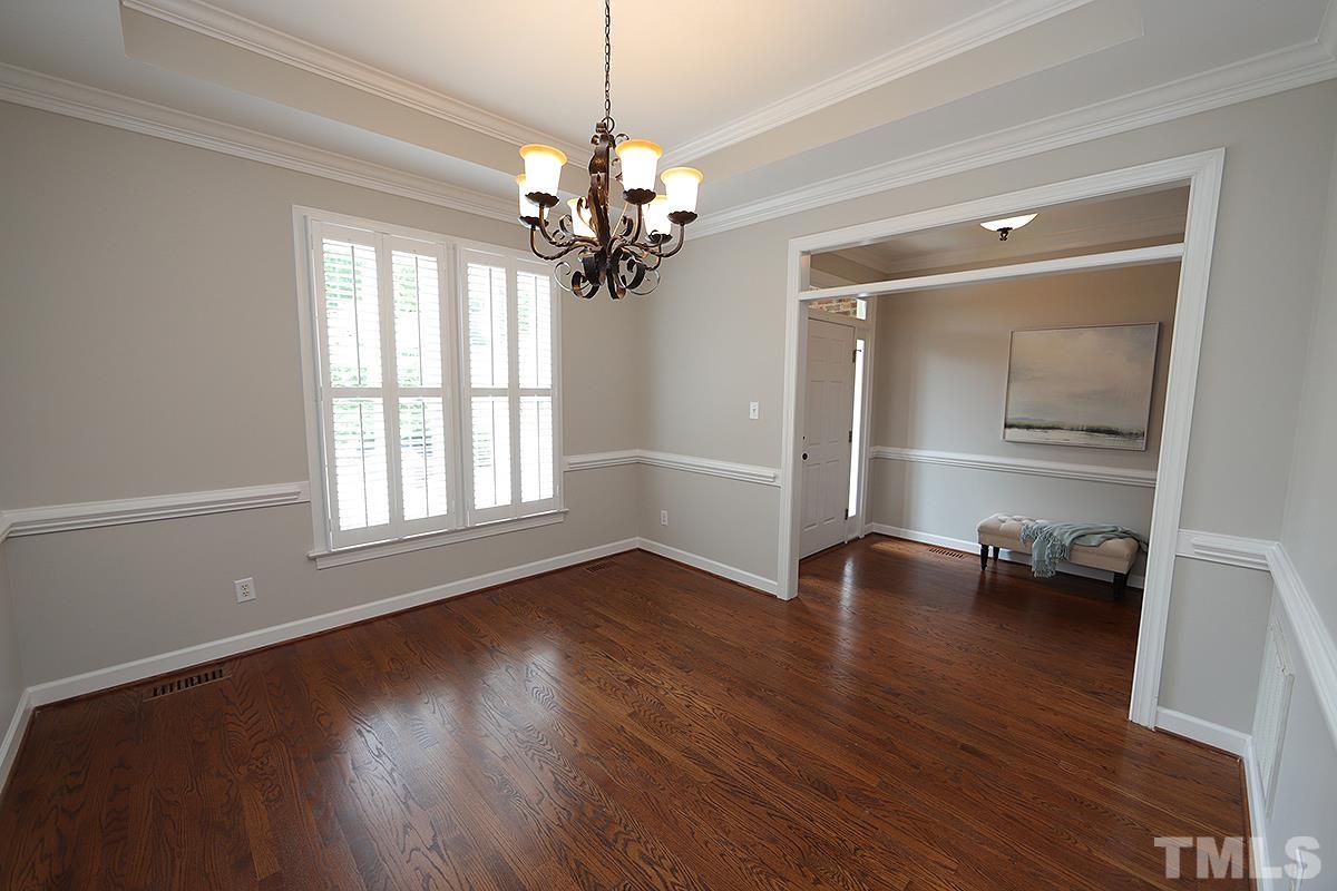 6317 Belle Crest Drive Raleigh, NC 27612 - Photo 9 of 29 a view of an empty room with wooden floor and a window