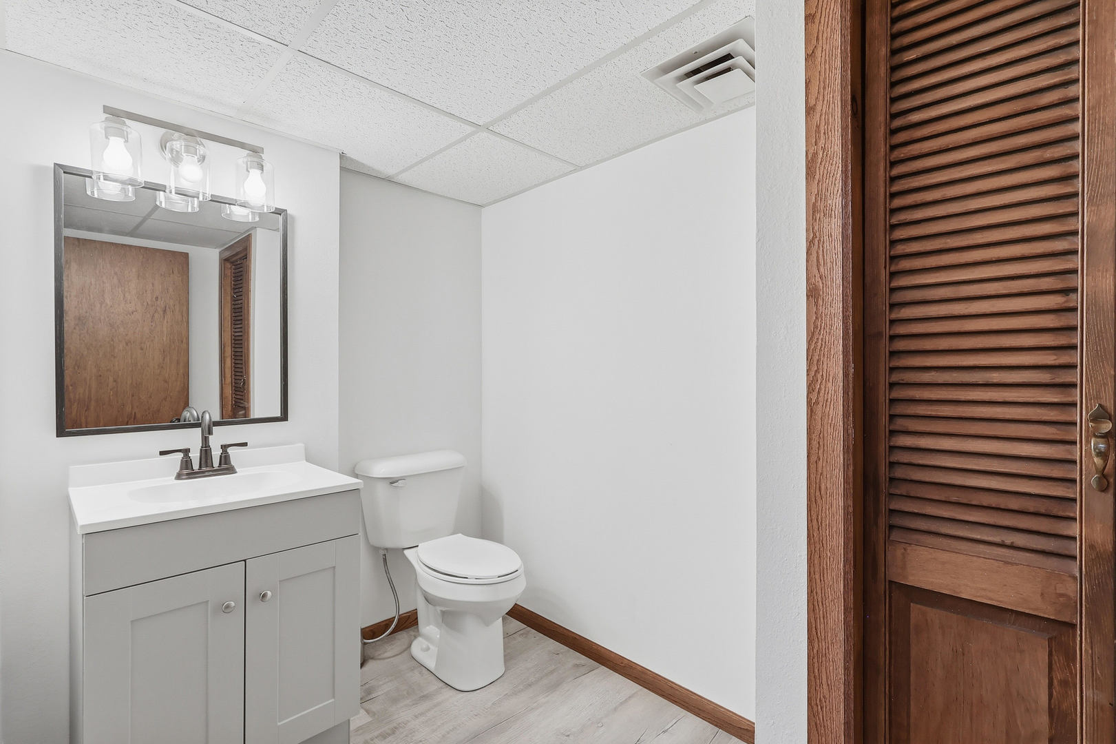4314 Spring Street Davenport, IA 52807 - Photo 46 of 51 a bathroom with a toilet a sink and mirror