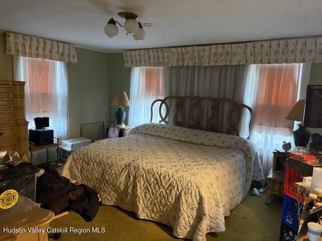 504 Greenkill Road Kingston, NY 12401 - Photo 8 of 18 a bed sitting in a bedroom next to a window with pc on the table and a flat screen tv
