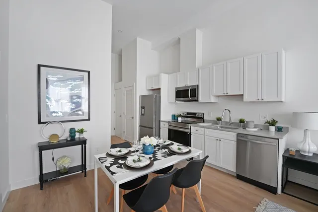 a kitchen with stainless steel appliances kitchen island granite countertop a stove a sink and a refrigerator