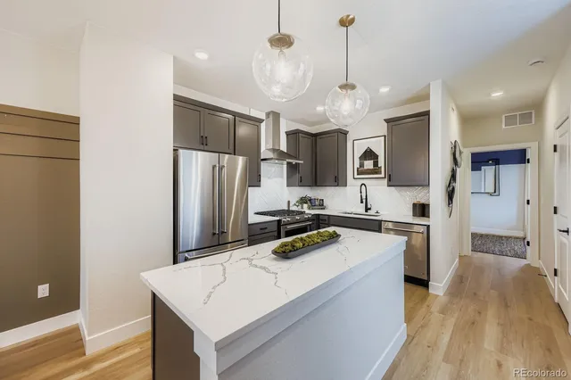 a kitchen with kitchen island a counter top space stainless steel appliances and cabinets