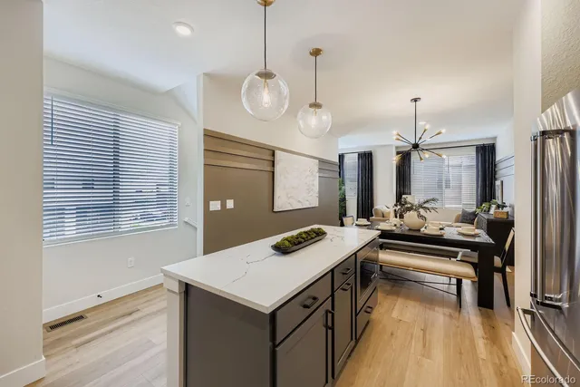 a kitchen with a stove a counter top space a sink and living room view