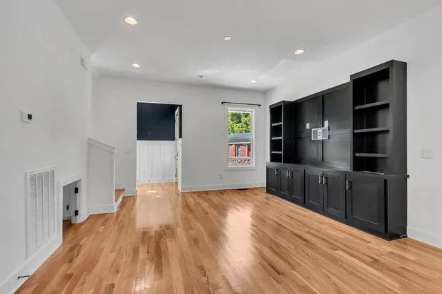 a view of a kitchen with wooden floor and a refrigerator