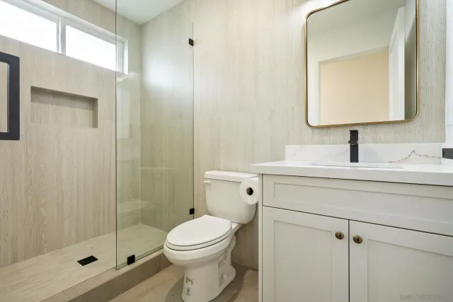 a bathroom with a sink a toilet and shower