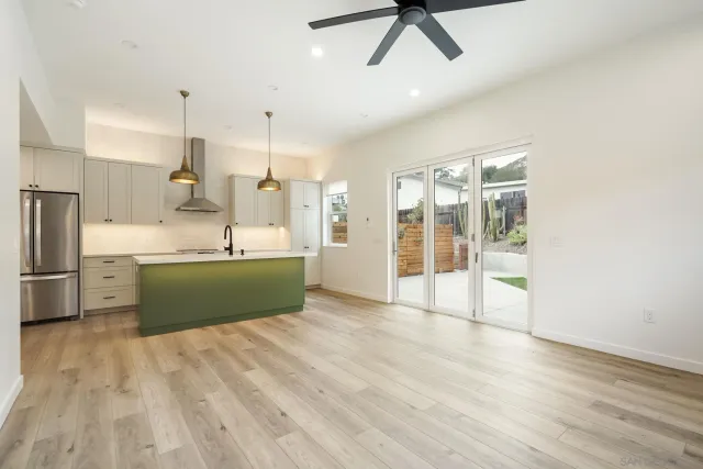 a kitchen with stainless steel appliances kitchen island granite countertop a refrigerator and a sink