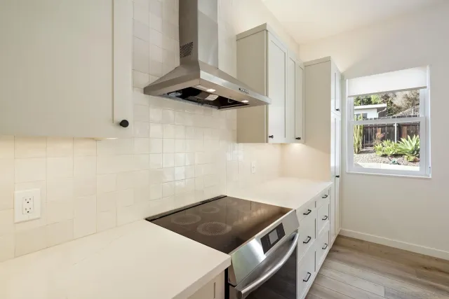 a kitchen with stainless steel appliances a stove and a window