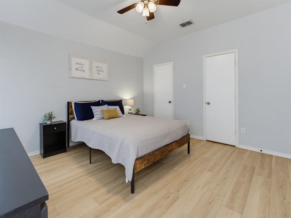 600 Stirling Road Rhome, TX 76078 - Photo 24 of 38 Bedroom featuring light wood-finish flooring, light gray walls, and a vaulted ceiling