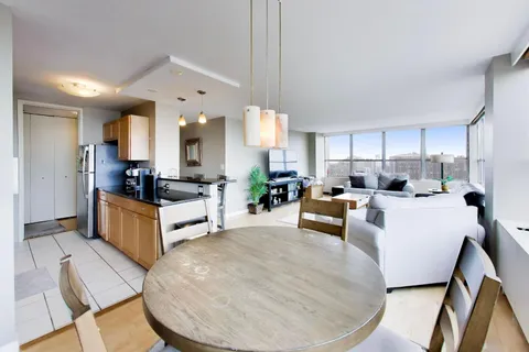 a large white kitchen with a large window and stainless steel appliances