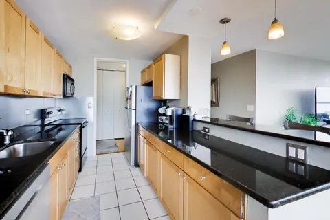a large kitchen with stainless steel appliances a sink a stove and cabinets