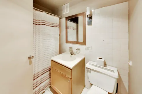a bathroom with a sink toilet vanity and shower