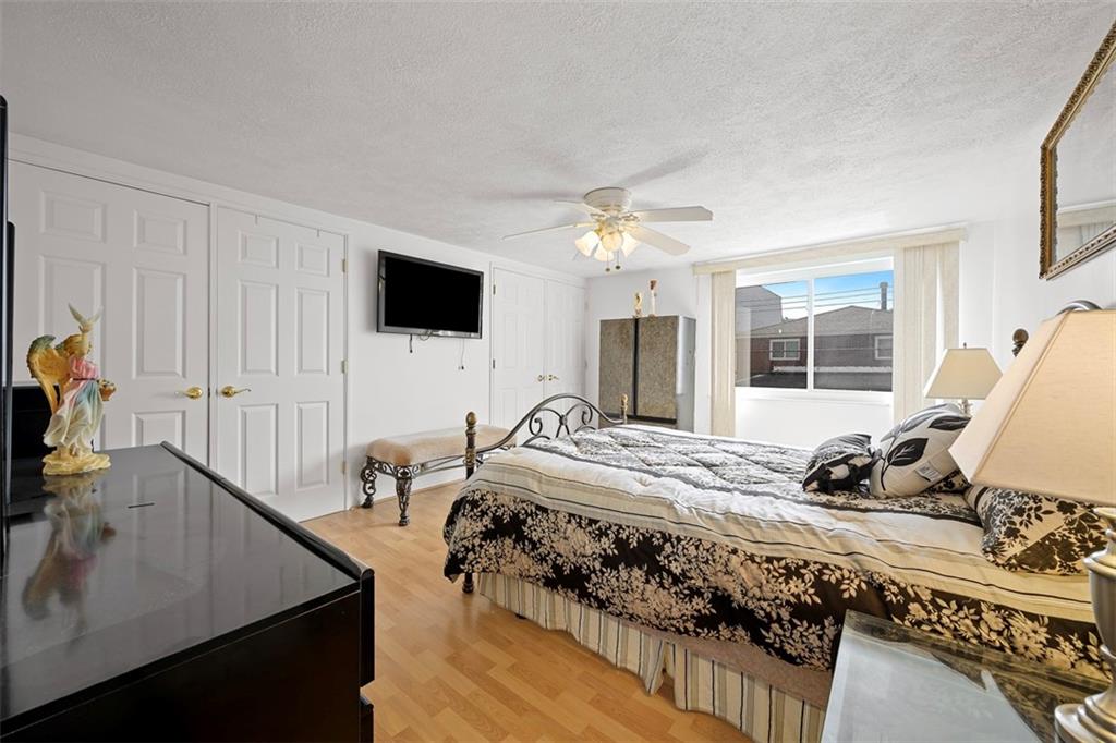 213 18th Street Pittsburgh, PA 15215 - Photo 18 of 42 a bed room with a bed and a flat tv screen on a dresser