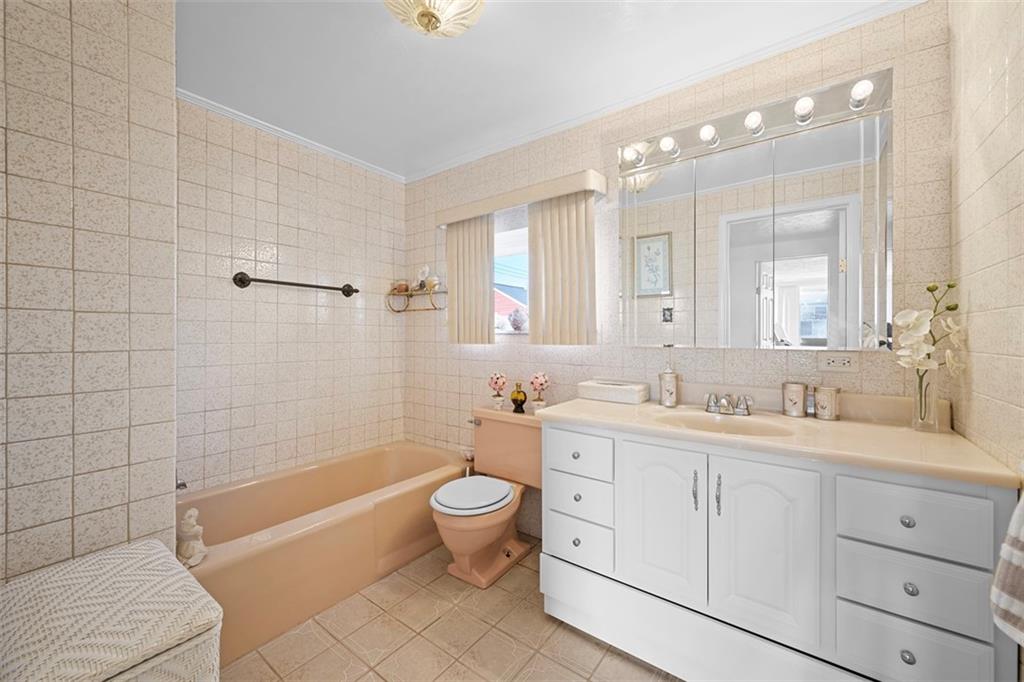 213 18th Street Pittsburgh, PA 15215 - Photo 21 of 42 a bathroom with a double vanity sink a toilet a mirror and shower