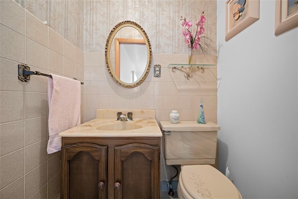 213 18th Street Pittsburgh, PA 15215 - Photo 25 of 42 a bathroom with a sink a toilet and a mirror