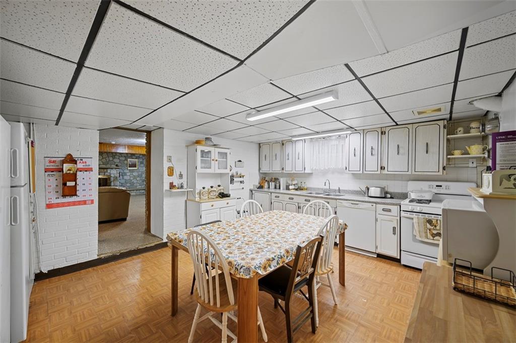 213 18th Street Pittsburgh, PA 15215 - Photo 29 of 42 a kitchen with a stove a table and chairs in it