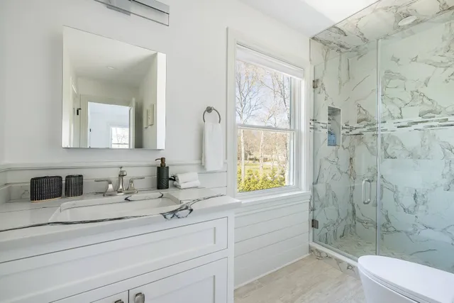 a bathroom with a sink a toilet and shower